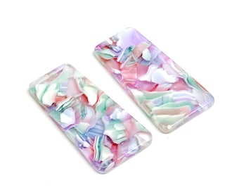 May include: Two rectangular hair clips with a marbled pattern in shades of pink, green, and purple.