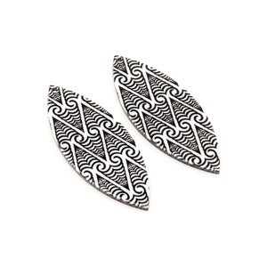 May include: A pair of black and white leaf-shaped earrings with a geometric pattern.
