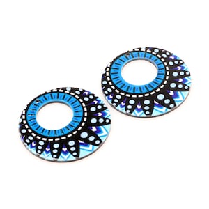 May include: Two round, blue and black patterned wooden earrings with a large hole in the centre.
