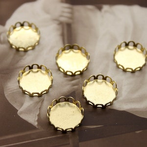 May include: Five gold-toned metal round bezel settings with scalloped edges. The bezels are empty and ready to be filled with a cabochon.