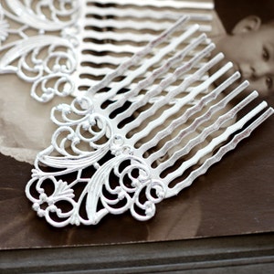 Può includere: Due pettini per capelli argentati con intricati disegni a filigrana. I pettini hanno un aspetto decorativo e ornato e sono perfetti per aggiungere un tocco di eleganza a qualsiasi acconciatura.