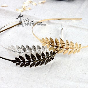 May include: Two gold-toned headbands with leaf designs. One headband is silver and the other is gold.