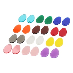 May include: Assortment of 20 colorful oval-shaped acrylic resin cabochons. The cabochons are in various colors, including red, orange, yellow, green, blue, purple, pink, brown, gray, and white.