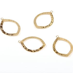 May include: Four gold-toned metal pendant charms in the shape of a teardrop with a textured surface. Each charm has a small loop at the top for attaching to jewelry.