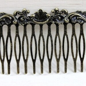 May include: A gold-toned metal hair comb with a decorative floral design. The comb has 12 teeth.