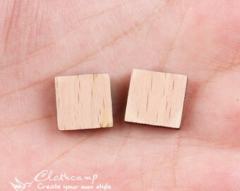 May include: Two small, square wooden pieces, both light brown in color. The wood grain is visible on the surface of the pieces.
