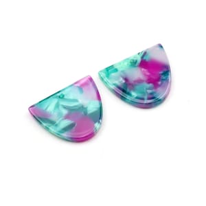 Könnte beinhalten: Zwei halbkreisförmige Ohrringe aus Harz mit einem marmorierten Muster in Rosa-, Grün- und Weißtönen.