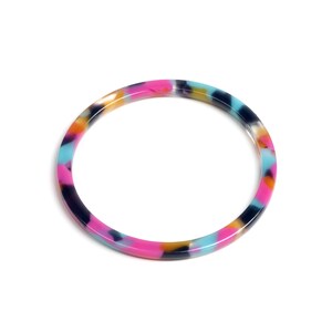 May include: A colorful bangle bracelet with a marbled pattern in shades of pink, blue, black, and yellow.