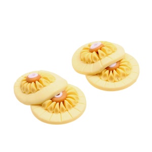 May include: Two sets of yellow clay flower buttons with orange centers and white centers. The buttons are stacked on top of each other.