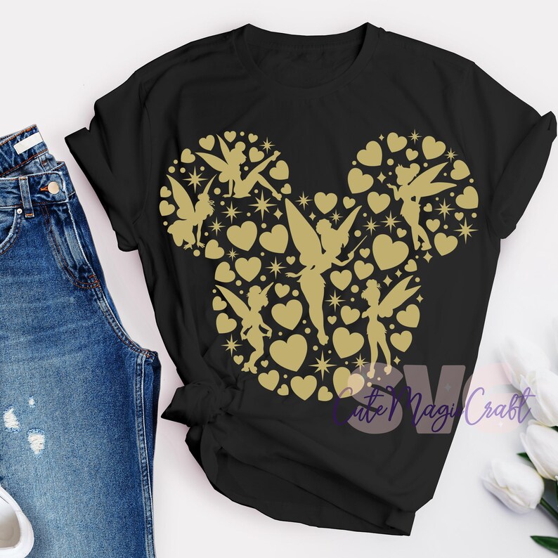 May include: Black t-shirt with a gold design in the shape of Mickey Mouse's head. The design is filled with hearts, stars, and fairy silhouettes. The text "Cute Magi Craft" is visible in the lower right corner.