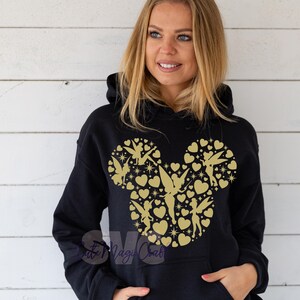 May include: Black hoodie with a gold Mickey Mouse head design. The design is made up of hearts, stars, and fairy silhouettes. The sweatshirt has a front pocket and a drawstring hood.