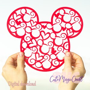 Puede incluir: Un recorte de papel rojo con la forma de la cabeza de Mickey Mouse, lleno de corazones y formas de la cabeza de Mickey Mouse. Las palabras "Descarga digital" están impresas en rosa. Las palabras "Cute Magic Craft" están impresas en morado.