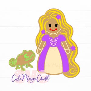 Può includere: Un biscotto di pan di zenzero a forma di principessa con lunghi capelli biondi, un vestito viola e una gonna beige. Un camaleonte verde e marrone è accanto alla principessa. Il testo "Cute Magic Craft" è in basso.