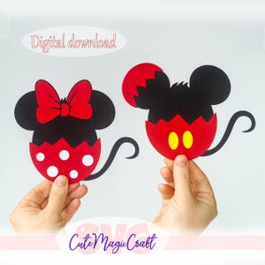 May include: Two black and red Mickey and Minnie Mouse head cutouts. Minnie has a red bow and white polka dots. Mickey has yellow oval eyes. The words "Digital download" and "Cute Magic Craft" are in the image.
