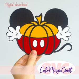 May include: A digital download graphic featuring a stylized pumpkin with black mouse ears, white cartoon gloves, and two white oval buttons on a red and yellow pumpkin body. The text Digital download is visible at the top left corner.