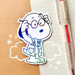 May include: A Snoopy sticker in a doctor's coat and glasses, with a blue and green gradient. The sticker is on a notebook with a red pen. The pen has Japanese text. Decorative cloud and star shapes surround the sticker.