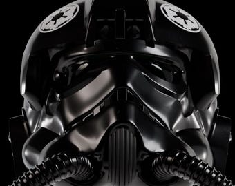 May include: A glossy black TIE fighter pilot helmet featuring a dark, angular faceplate with a central vertical ribbed intake. Two circular white Imperial cog emblems are positioned on the upper sides, and two black corrugated breathing hoses extend from the base.