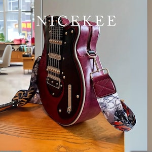 May include: A burgundy guitar-shaped handbag with a black and silver design. The bag has a patterned strap and a zipper closure. The word "NICEKEE" is printed on the top of the bag.