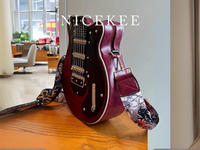 May include: A burgundy guitar-shaped handbag with a black and silver design. The bag has a patterned strap and a zipper closure. The word "NICEKEE" is printed on the top of the bag.