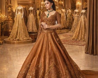 Puede incluir: Una mujer con un vestido de gala color cobre con intrincados bordados dorados y un chal a juego. El vestido presenta una falda amplia y un corpiño ajustado. El fondo incluye varios maniquíes con vestidos dorados y una gran lámpara de araña.