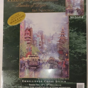 May include: A Thomas Kinkade Painter of Light San Francisco embellished cross stitch kit, No. 51414. The packaging features a full-color printed design of a city street with cable cars, measuring 12 inches by 16 inches, by Candamar Designs.