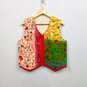 Handmade colorful Indian embroidered vest featuring cream, pink, yellow, green and turquoise fabric panels with detailed red floral and vine embroidery, V-neck sleeveless waistcoat design and red edging, perfect for boho fashion, ethnic outfits, festivals, vacations and everyday layering.