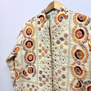 Beautiful floral motifs, geometric embroidery patterns, and handcrafted mirror accents create a rich textured look perfect for bohemian fashion lovers, festival outfits, Indo-western styling, vacation wear, casual layering, and sustainable artisan fashion collections.