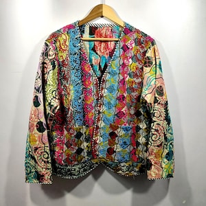 Könnte beinhalten: Eine farbenfrohe Jacke mit Muster, V-Ausschnitt und langen Ärmeln. Die Jacke hat ein Patchwork-Design mit verschiedenen Farben wie Blau, Rosa, Gelb und Grün. Sie hat einen Knopfverschluss und zwei Taschen.