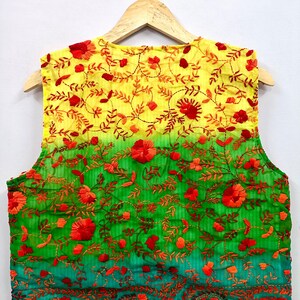 May include: A sleeveless vest featuring an ombre gradient transitioning from yellow at the top to green at the bottom. The garment is decorated with dense, intricate embroidery of red and orange floral patterns and vine motifs throughout.
