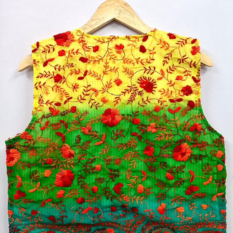 May include: A sleeveless vest featuring an ombre gradient transitioning from yellow at the top to green at the bottom. The garment is decorated with dense, intricate embroidery of red and orange floral patterns and vine motifs throughout.