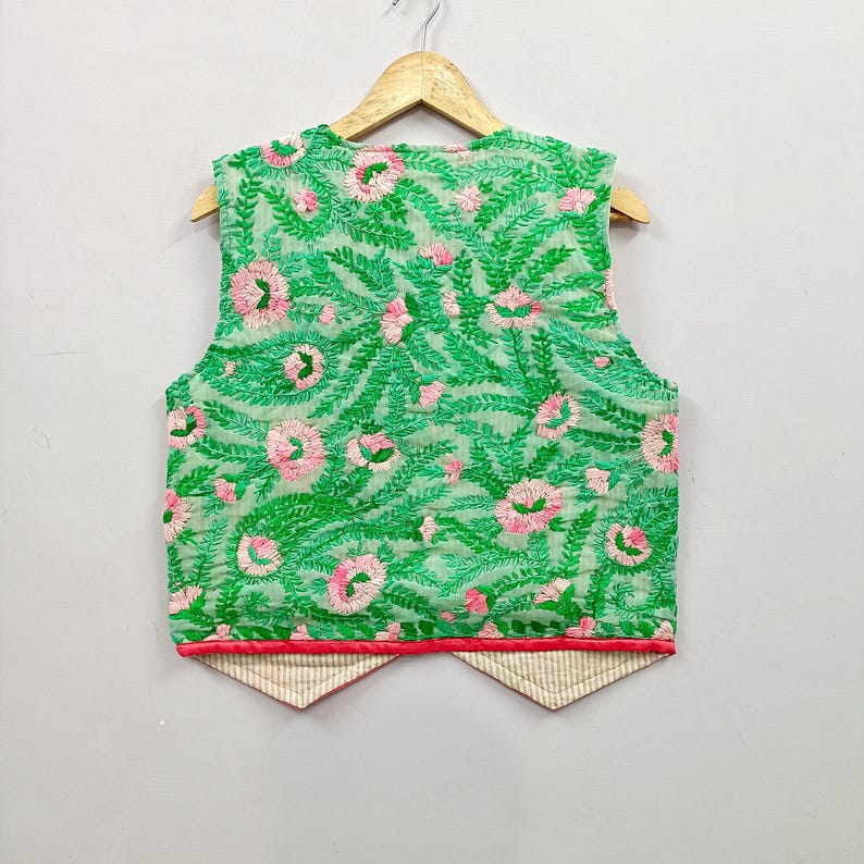 unique sleeveless waistcoat features beautiful floral and leafy embroidery in bright green, red, orange and blue over contrasting grey and black fabric panels.