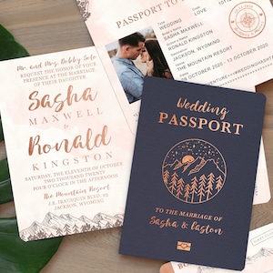 May include: A wedding invitation suite with a pink and white watercolor background. The invitation features the names Sasha Maxwell and Ronald Kingston, the date and time of the wedding, and the location. The RSVP card features a mountain range illustration. The wedding passport features a navy blue cover with a copper foil design of a mountain range and the text "Wedding Passport" and "To the marriage of Sasha & Laston".