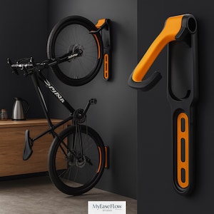 Könnte beinhalten: Schwarzer und orangefarbener Wand-Fahrradständer. Der Ständer ist für ein Fahrrad konzipiert, mit einem Fahrrad an der Wand montiert. Der Ständer hat einen gebogenen orangefarbenen Arm und eine schwarze Basis. Das Fahrrad ist schwarz mit dem Wort "SPINA" auf dem Rahmen.