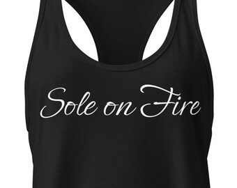 May include: Black racerback tank top with the text "Sole on Fire" in a cursive font. The tank top has a scoop neck and a racerback design, suitable for athletic activities or casual wear.