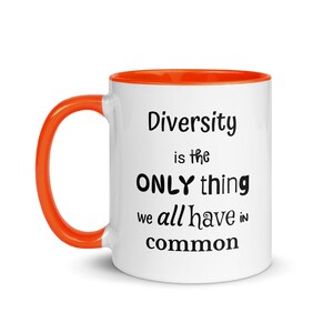Puede incluir: Taza de cerámica blanca con asa e interior naranja. La taza presenta el texto "Diversity is the ONLY thing we all have in common" en letras negras. Un diseño sencillo pero impactante.