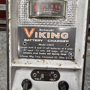 以下が含まれることがあります： 白と黒の金属製ケースに入った、ヴィンテージのバイキングバッテリー充電器、モデルVA612。アンペアを表示するメーター、6または12ボルトの電圧セレクター、および「VIKING BATTERY CHARGER」のテキストを備えています。 UL安全認証が含まれています。