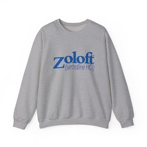 May include: A heather gray sweatshirt with the word "Zoloft" in blue, with "(sertraline HCI)" below it. The sweatshirt has a crew neck and long sleeves. The text is centered on the front of the garment.