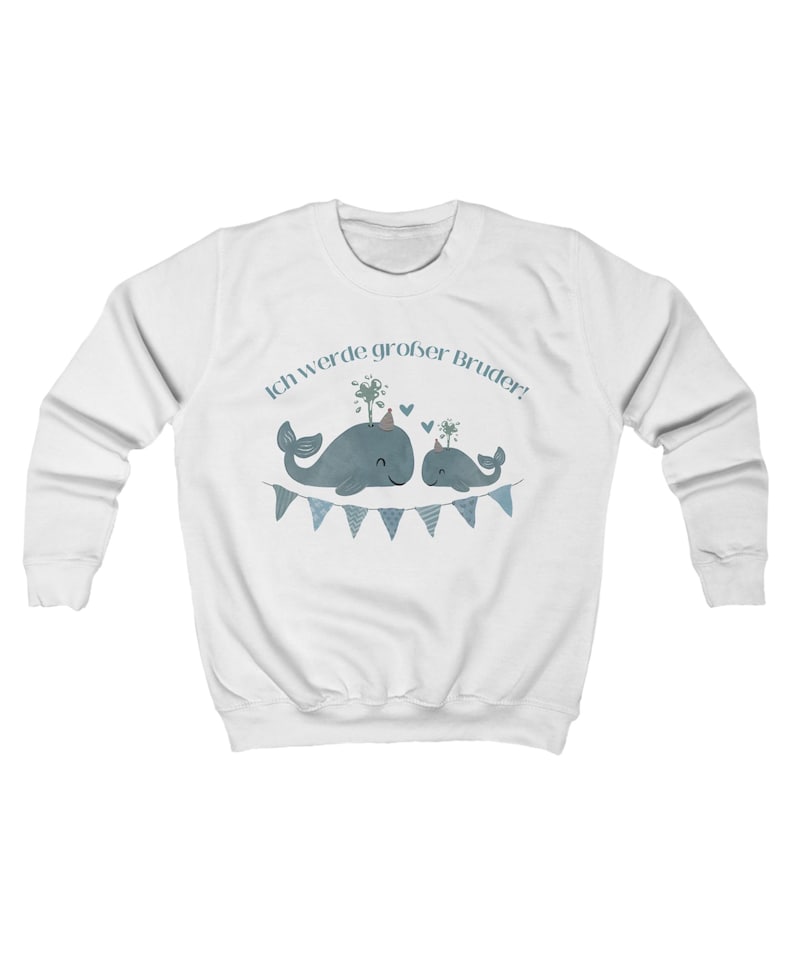 May include: White sweatshirt featuring a blue whale graphic with the text "Ich werde gro&szlig;er Bruder!" above the whales. The whales are decorated with party hats and are above a blue pennant banner. The sweatshirt has long sleeves and a crew neck.