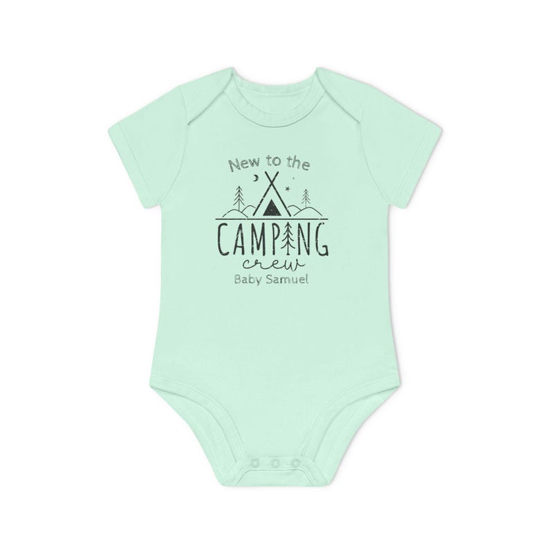 May include: A light green baby onesie with short sleeves. The front features the text "New to the CAMPING crew" with a tent and tree graphic. Below the text is "Baby Samuel" in a script font.