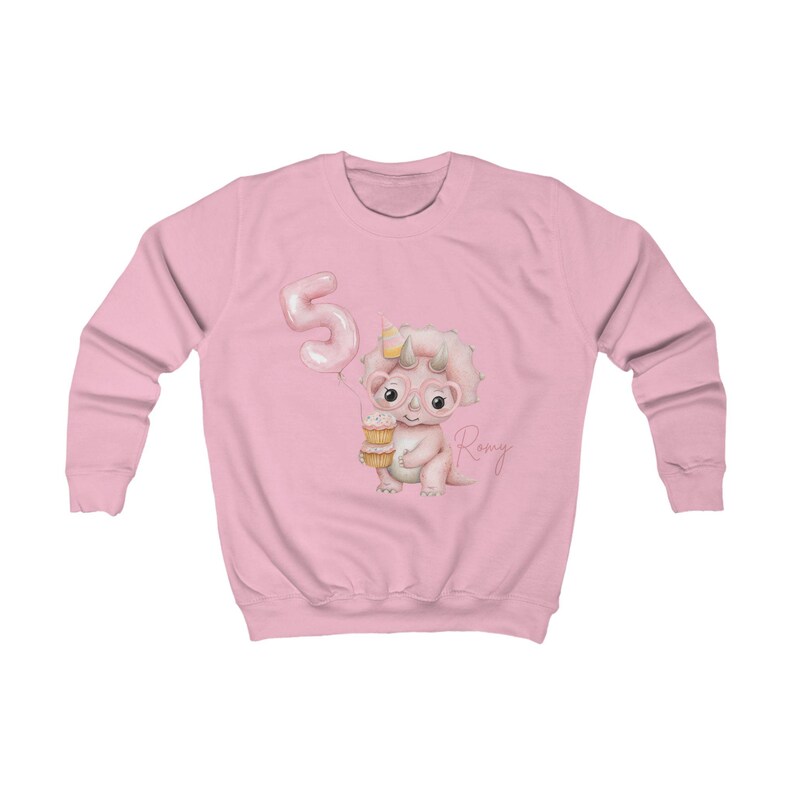 Puede incluir: Sudadera rosa claro con un dinosaurio de dibujos animados sosteniendo un cono de helado y usando gafas. Un globo rosa con el n&uacute;mero 5 est&aacute; a la izquierda. El nombre "Romy" est&aacute; escrito en cursiva a la derecha.