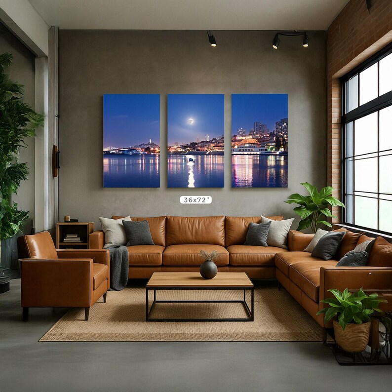 A modern living room with a large sectional sofa, a coffee table, and a large wall art depicting a city skyline at night.