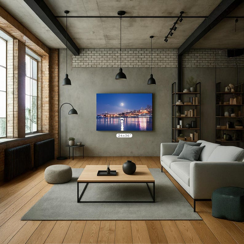 A modern living room with a large flat-screen TV mounted on the wall, a wooden coffee table, a white sofa, and a brick wall with exposed beams.