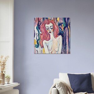 May include: A colorful painting of a woman with long pink hair and closed eyes. The artwork features a nude figure with a light skin tone, set against a backdrop of abstract, vertical brushstrokes in various colors, including blue, pink, and yellow.