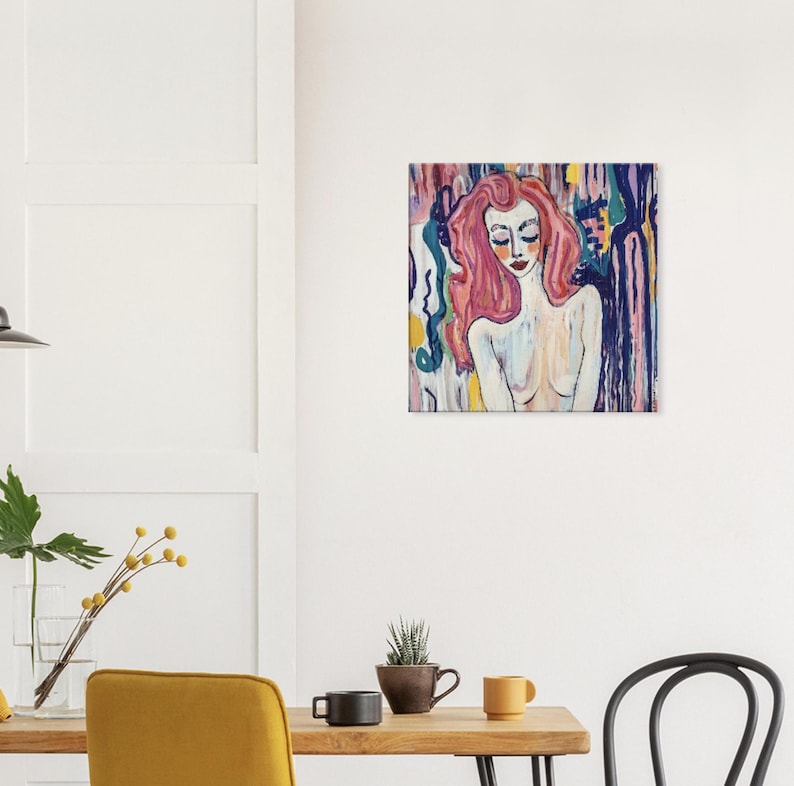 May include: Square canvas art featuring a portrait of a woman with pink hair and closed eyes. The artwork uses a palette of pinks, blues, and yellows, with a background of vertical brushstrokes. The woman's skin is painted in soft, neutral tones.