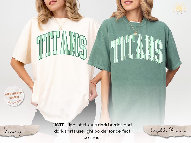 May include: Two short-sleeve crewneck t-shirts, one in ivory and one in light green, both featuring the word TITANS in a large, arched, striped collegiate font across the chest. The ivory shirt has dark green lettering, while the light green shirt has white lettering.