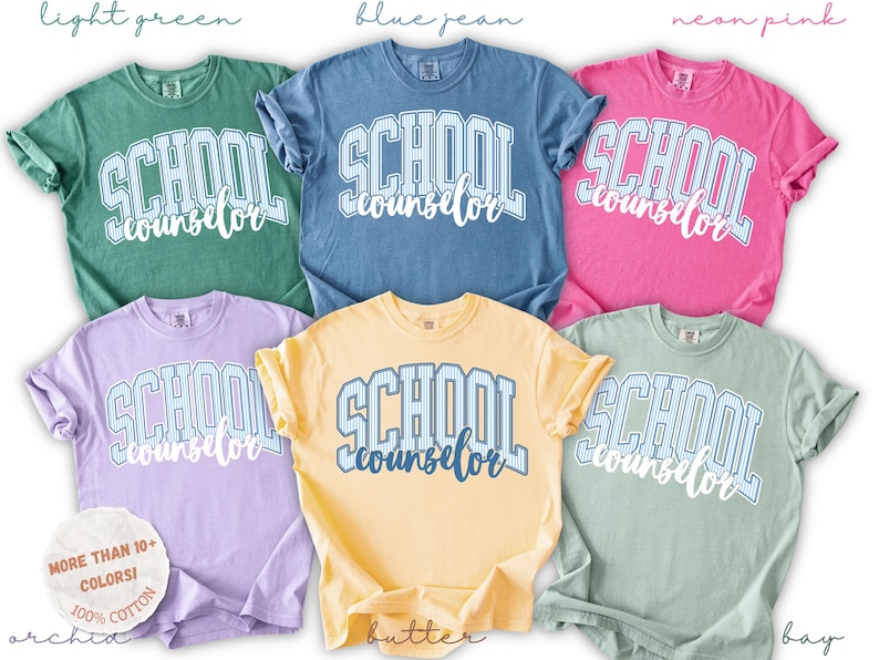 Puede incluir: Seis camisetas de manga corta en colores verde claro, azul vaquero, rosa ne&oacute;n, orqu&iacute;dea, mantequilla y laurel. Cada camiseta presenta el texto SCHOOL counselor en una fuente universitaria con un patr&oacute;n de rayas. Una etiqueta circular indica m&aacute;s de 10 colores.