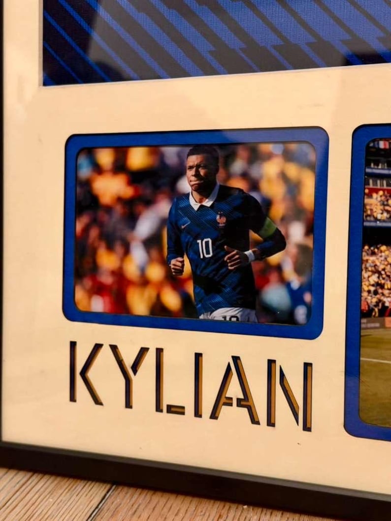 May include: Framed photo featuring a soccer player in a blue jersey with the number 10. The name "KYLIAN" is cut out in large letters below the photo. The frame has a blue border and a black frame.
