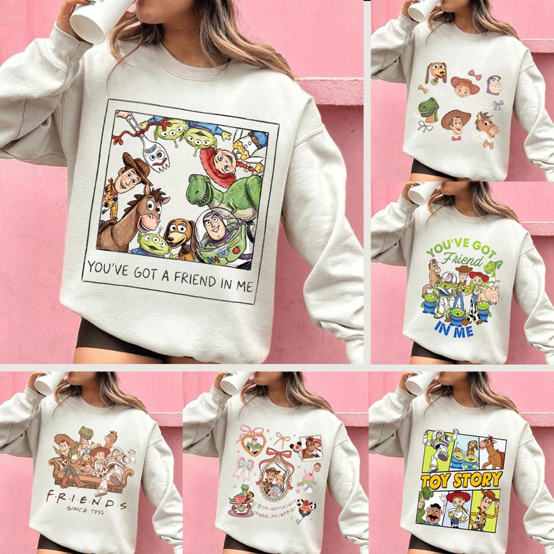May include: A collection of light gray sweatshirts featuring various designs from the animated film "Toy Story." One sweatshirt displays a framed image of characters with the text "YOU'VE GOT A FRIEND IN ME." Other designs include character portraits and the text "TOY STORY."