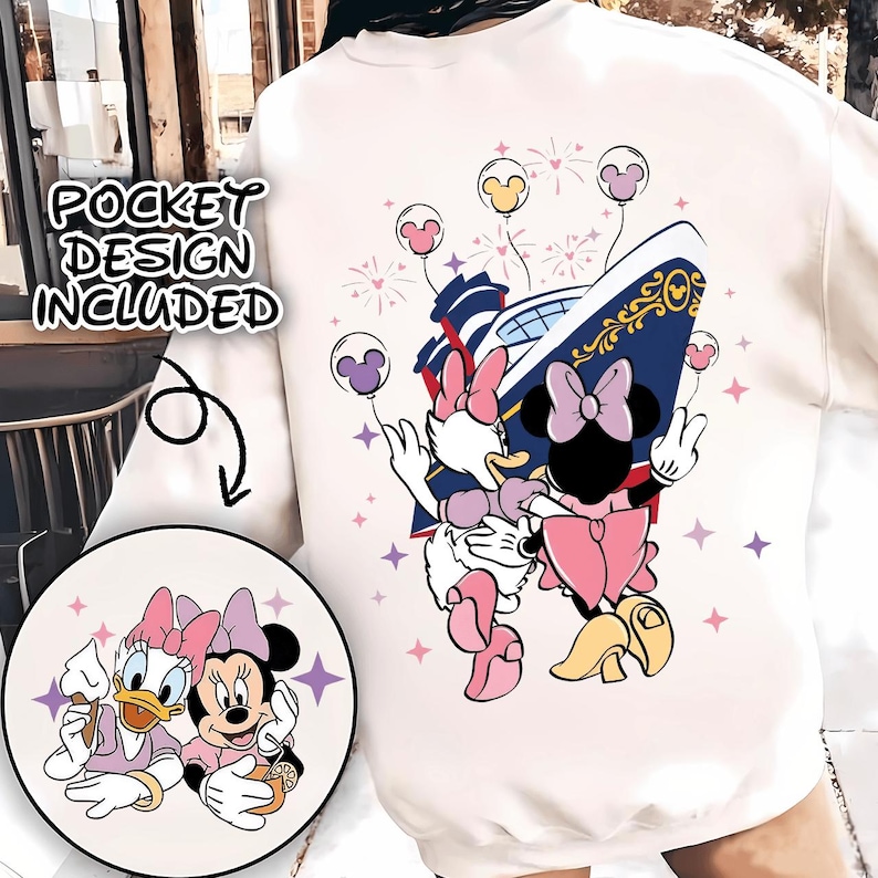 May include: Cream sweatshirt with a graphic of Minnie Mouse and Daisy Duck, a cruise ship, and balloons. The design includes the text "POCKET DESIGN INCLUDED" and a circular pocket design with the characters. The design is in pink, purple, yellow, and blue.