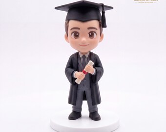 May include: A miniature figurine of a graduate wearing a black graduation cap with a tassel, a black gown, and a gray suit with a tie. The figure holds a white diploma tied with a red ribbon. The character has brown hair and eyes.